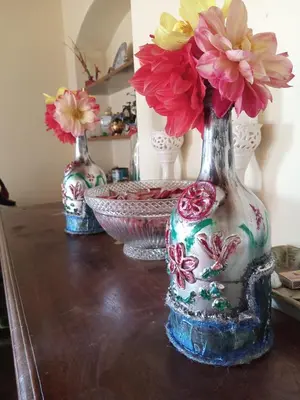 three vases with flowers in them sitting on a table at Zeus Bungalow in Kotagiri