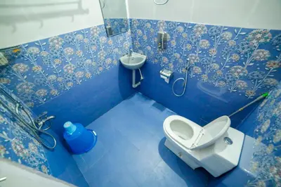 a blue bathroom with a toilet and a sink at Belljem Homes -your own private resort -6 BHK S in Trichūr