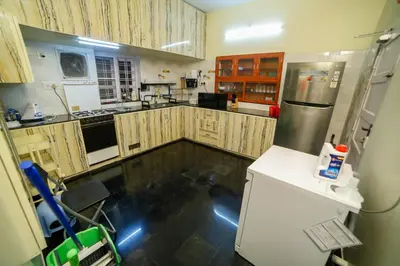 a kitchen with wooden cabinets and stainless steel appliances at Belljem Homes -your own private resort -6 BHK S in Trichūr