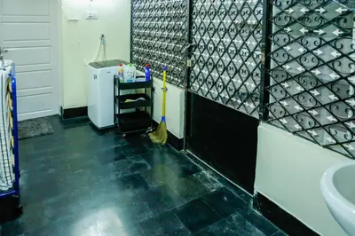 a bathroom with a sink and a urinal at Belljem Homes -your own private resort -6 BHK S in Trichūr