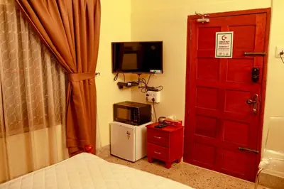 a bedroom with a bed and a tv and a door at Belljem Homes -your own private resort -7 BHK in Trichūr