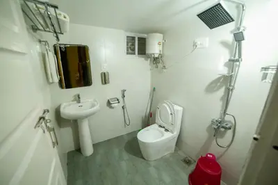 a small bathroom with a toilet and a sink at Belljem Homes -your own private resort -7 BHK in Trichūr