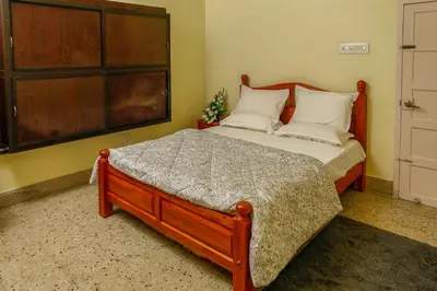 a bedroom with a large bed with a wooden headboard at Belljem Homes -your own private resort -7 BHK in Trichūr
