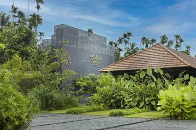 a resort with a tall building in the background at Saptha Resort and Spa in Sultan Bathery