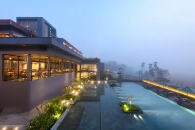 a hotel with a swimming pool at night at Saptha Resort and Spa in Sultan Bathery