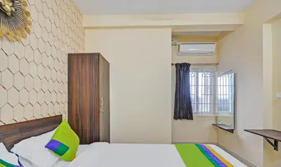 a bedroom with a white bed with a green pillow at Treebo Everest Residency Tidel Park, 15 Mins From Coimbatore International Airport in Coimbatore