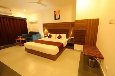 a hotel room with a bed and a chair at HOTEL LA SERENE Mattannur in Mattanūr