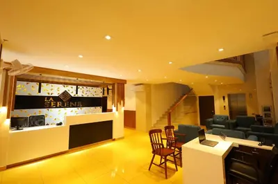 a lobby with a waiting area with chairs and a table at HOTEL LA SERENE Mattannur in Mattanūr