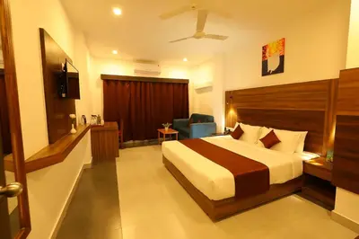 a hotel room with a bed and a chair in it at HOTEL LA SERENE Mattannur in Mattanūr