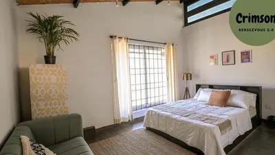 a bedroom with a bed and a couch and a window at Rendezvous in Coonoor