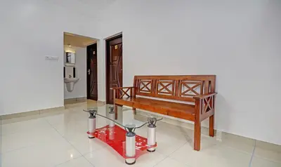 a room with a bench and a glass table at Nirupama,Hotel Aluva 700 Mtr From Aluva Railway Station in Alwaye