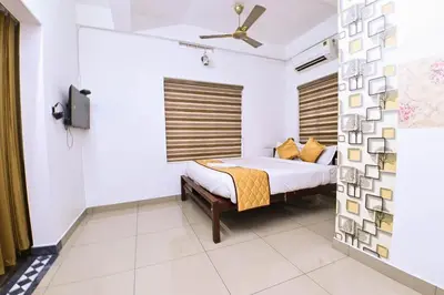 a bedroom with a bed and a ceiling fan at Nirupama,Hotel Aluva 700 Mtr From Aluva Railway Station in Alwaye