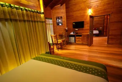 a room with a bed and a room with a television at LakeRose Wayanad Resort - Water Front Grandeur in Kalpetta