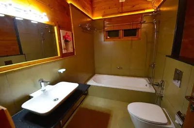 a bathroom with a sink and a toilet and a tub at LakeRose Wayanad Resort - Water Front Grandeur in Kalpetta