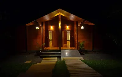 a house at night with the front door lit up at LakeRose Wayanad Resort - Water Front Grandeur in Kalpetta