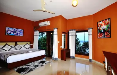 a bedroom with orange walls and a bed and windows at LakeRose Wayanad Resort - Lake view in Kalpetta