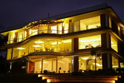 a large building with a lot of windows at night at LakeRose Wayanad Resort - Lake view in Kalpetta