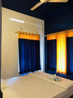 a bedroom with blue and orange curtains and a bed at Royal residency in Tindummal