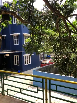 a blue building with a bench in front of it at Royal residency in Tindummal