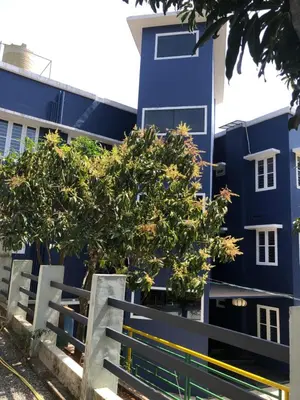 a blue building with trees in front of it at Royal residency in Tindummal