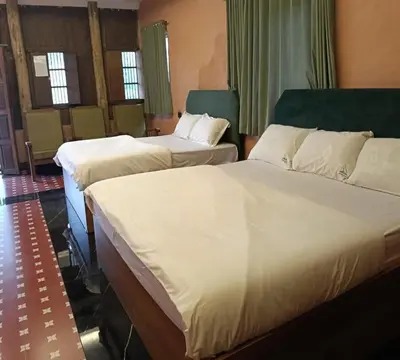 a hotel room with two beds in a room at Anandavana Jungle Living By LexStays - Kanthalloor-Marayur in Kanthalloor