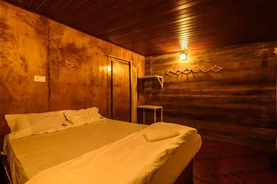 a bedroom with a bed in a wooden room at Anandavana Jungle Living By LexStays - Kanthalloor-Marayur in Kanthalloor