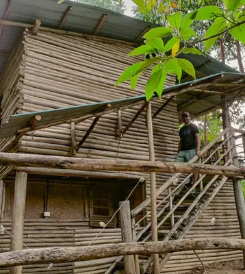 a man standing on the stairs of a tree house at Anandavana Jungle Living By LexStays - Kanthalloor-Marayur in Kanthalloor