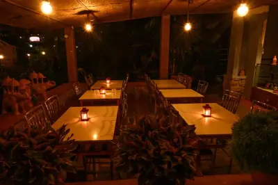 a group of tables in a restaurant with candles on them at Anandavana Jungle Living By LexStays - Kanthalloor-Marayur in Kanthalloor