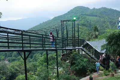 a group of people on a suspension bridge in the mountains at Casa Lucio Resorts in Mannārakkāt