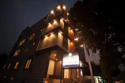 a building with a sign in front of it at night at MC Suites Mysuru in Mysore