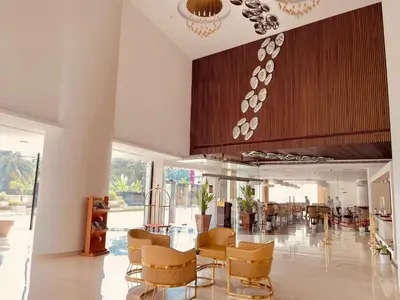 a lobby with a table and chairs in a building at Dimora Kozhikode in Kozhikode