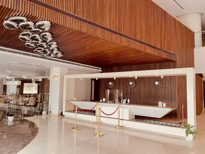 a lobby with a white counter and wooden walls at Dimora Kozhikode in Kozhikode