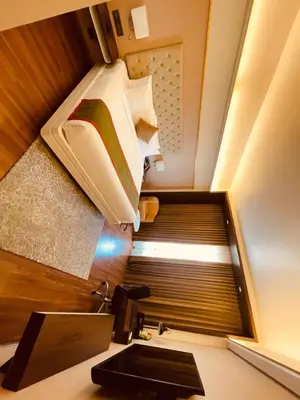 a bathroom with a sink and a bed in a room at Dimora Kozhikode in Kozhikode