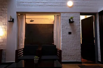 a living room with two chairs and a brick wall at S RIVER RESORTS in Cochin
