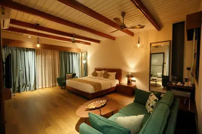 a bedroom with a bed and a living room at Vyna Hillock Resort in Vythiri
