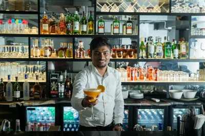 a man holding a drink in a bar at Zone Connect by The Park Coimbatore in Coimbatore