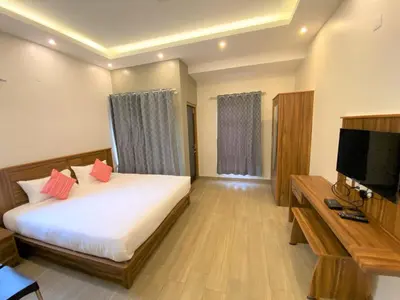 a hotel room with a bed and a television at Avalon Stays in Ooty
