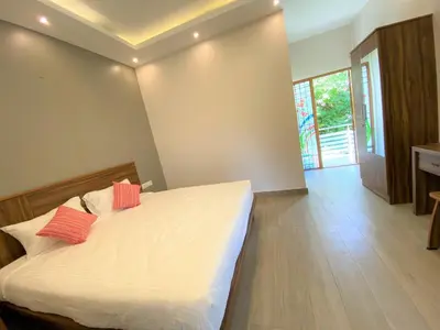 a bedroom with a bed with two red pillows on it at Avalon Stays in Ooty
