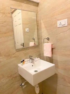 a bathroom with a white sink and a mirror at Avalon Stays in Ooty
