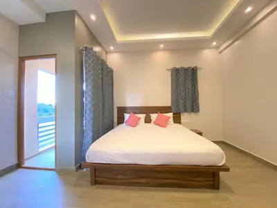 a bedroom with a bed with pink pillows on it at Avalon Stays in Ooty