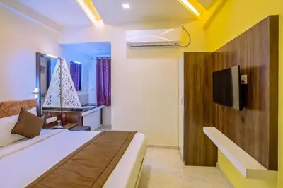 a hotel room with a bed and a tv at IVY RESIDENCY in Coimbatore