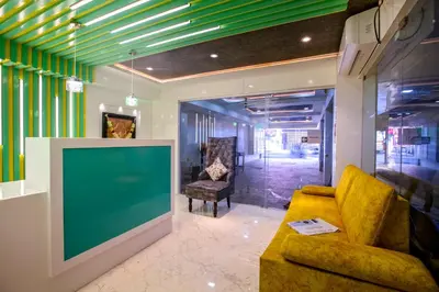 a living room with a yellow couch and a green screen at IVY RESIDENCY in Coimbatore