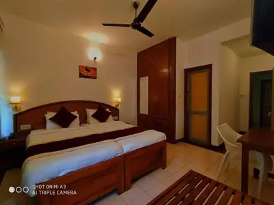 a bedroom with a large bed with a ceiling fan at KTDC Tamarind, Mannarkkad in Alanallūr