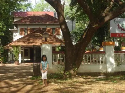 a little girl standing in front of a tree at KTDC Tamarind, Nilambur in Nilambūr