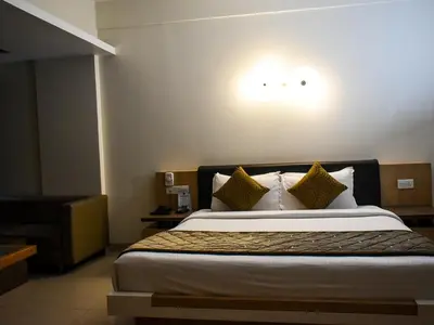 a hotel room with a bed with pillows at Nexstay Asma Tower in Kozhikode
