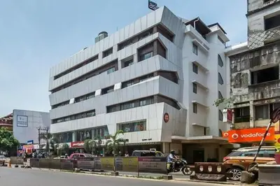 a large white building on the side of a street at Nexstay Asma Tower in Kozhikode