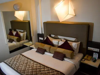 a hotel room with two beds and two mirrors at Nexstay Asma Tower in Kozhikode