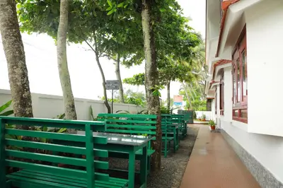 a row of green benches sitting next to a building at Cherai Beach Residency in Cherai Beach