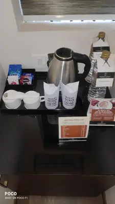 a counter top with a tea pot and dishes on it at Emperor-Hotel Rachana Continental Pvt Ltd in Kizhake Chālakudi