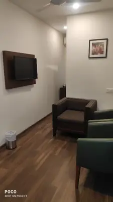 a waiting room with a couch and a flat screen tv at Emperor-Hotel Rachana Continental Pvt Ltd in Kizhake Chālakudi